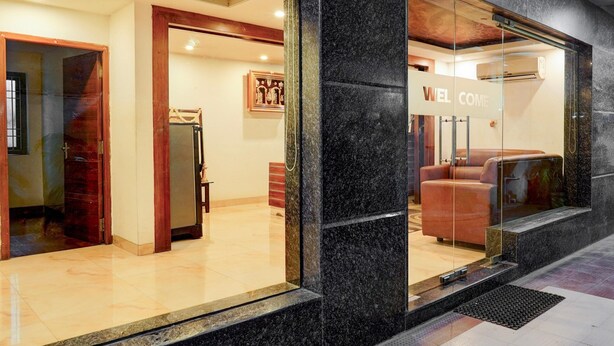 A reception area with a 'WELCOME' sign, a seating area with a sofa, and a reception desk. - Super Townhouse Arcot Road (Chennai)