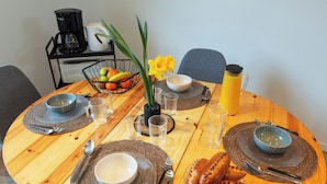 Una mesa de madera con fuentes, vasos, cubiertos y pan.