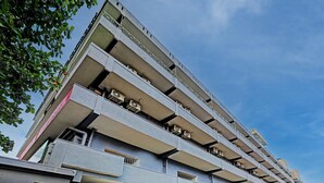 Un immeuble à plusieurs étages doté de balcons et de climatiseurs.