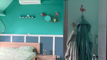A bedroom with a bed, bedside table, and a wall-mounted mirror.