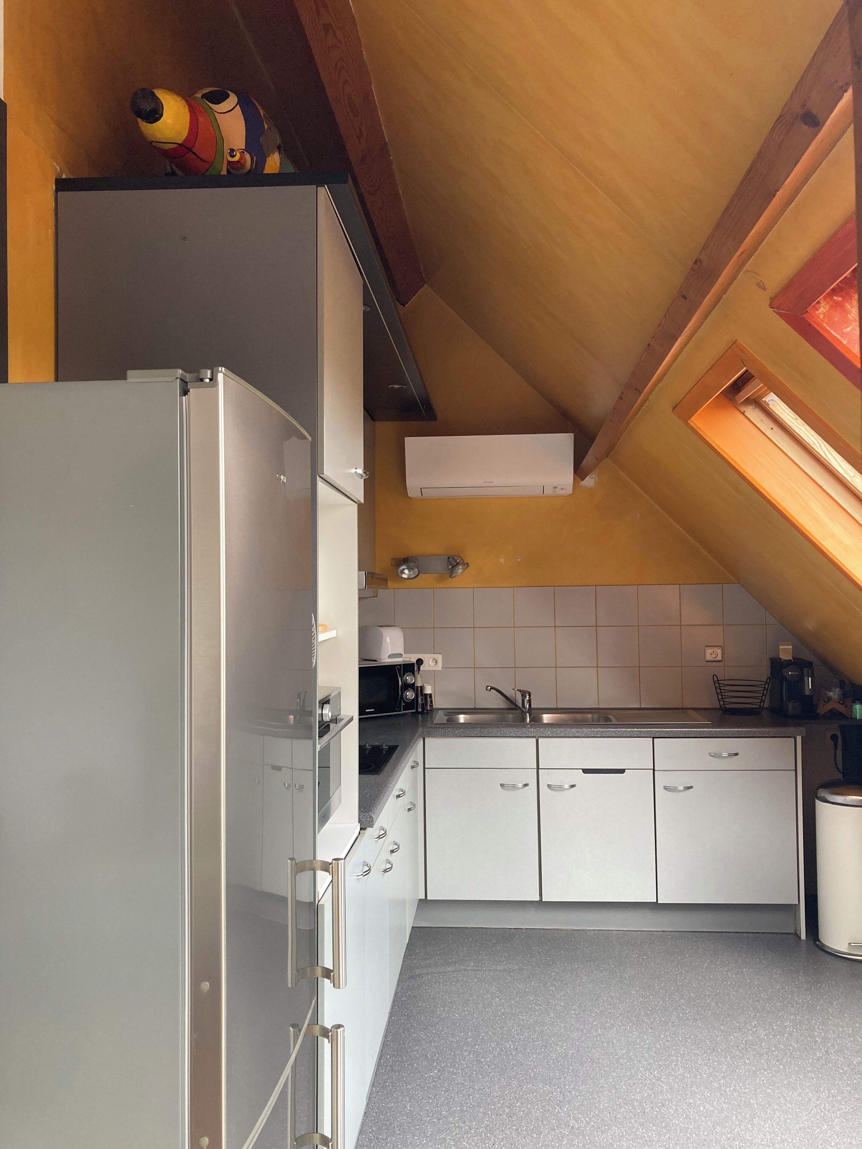 A kitchen with white cabinets, a stainless steel sink, and a microwave.