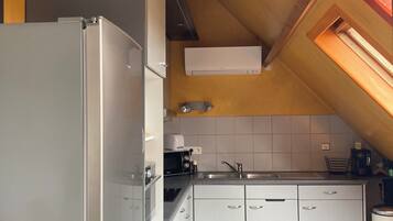 A kitchen with white cabinets, a stainless steel sink, and a microwave.