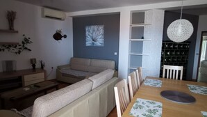 Una sala moderna con un sofá, una mesa de comedor y una araña.
