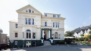 A two-story building with a classic architectural style, featuring a prominent entrance with steps and a sign that reads "ANNA". - Annan Hotel (Llandudno)