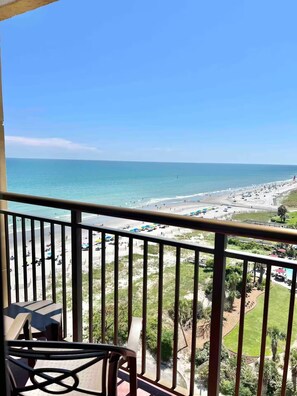Een balkon met uitzicht op een strand en de oceaan.