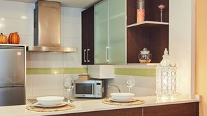 A modern kitchen with a refrigerator, microwave, and a dining area with two chairs. - apart. "the most flirtatious, in the DNA of Cadiz" in La Viña neighborhood, 2m. from Caleta beach. (Cádiz)