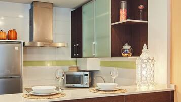 Una cocina moderna con refrigerador, microondas y comedor para dos personas.