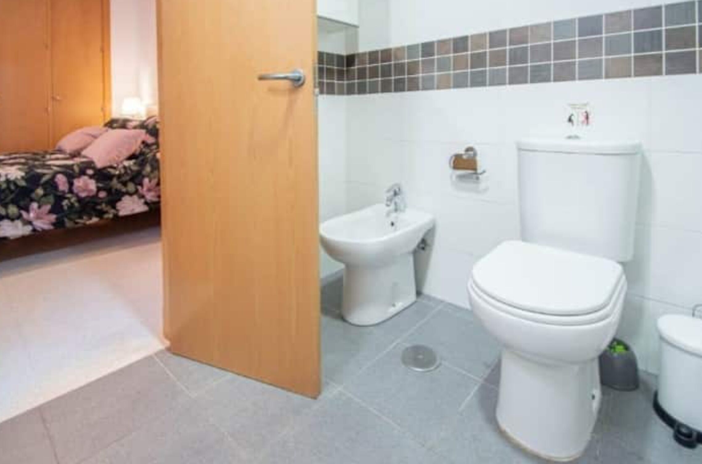 Un baño con inodoro, bidé y lavamanos.