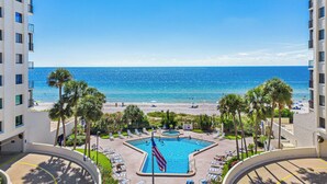 A resort with a swimming pool, beach, and ocean view.