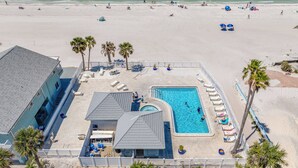 Un complexe hôtelier doté d’une piscine, d’un accès à la plage et de palmiers.