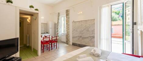 Une chambre d’hôtel comprenant un lit, une télévision, un coin repas et une salle de bain.