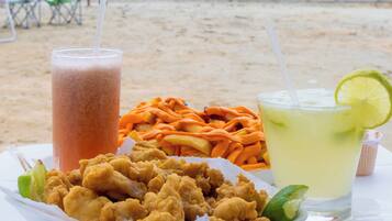 Na praia, guarda-sóis, toalhas de praia, bar na praia