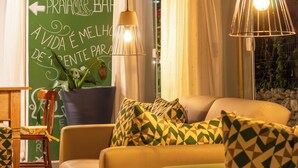 A cozy living room with a green chalkboard wall, a sofa with patterned cushions, and a potted plant. - MAR E PRAIA HOTEL (Ubatuba)