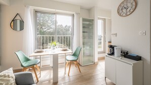 Eine moderne Küche mit Essbereich, einer Kaffeemaschine und einer Uhr an der Wand.