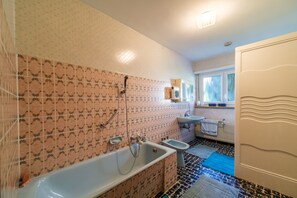 Ein Badezimmer mit einer Badewanne, einer Dusche und einem Waschbecken.