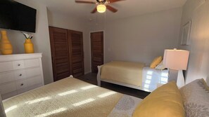 Une chambre à coucher avec un lit, une table de chevet, une lampe et une armoire.