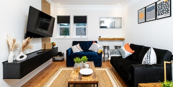 Relax in style! Our cozy living room features two comfy sofas and a 50” TV—perfect for movie nights or unwinding after a long day.