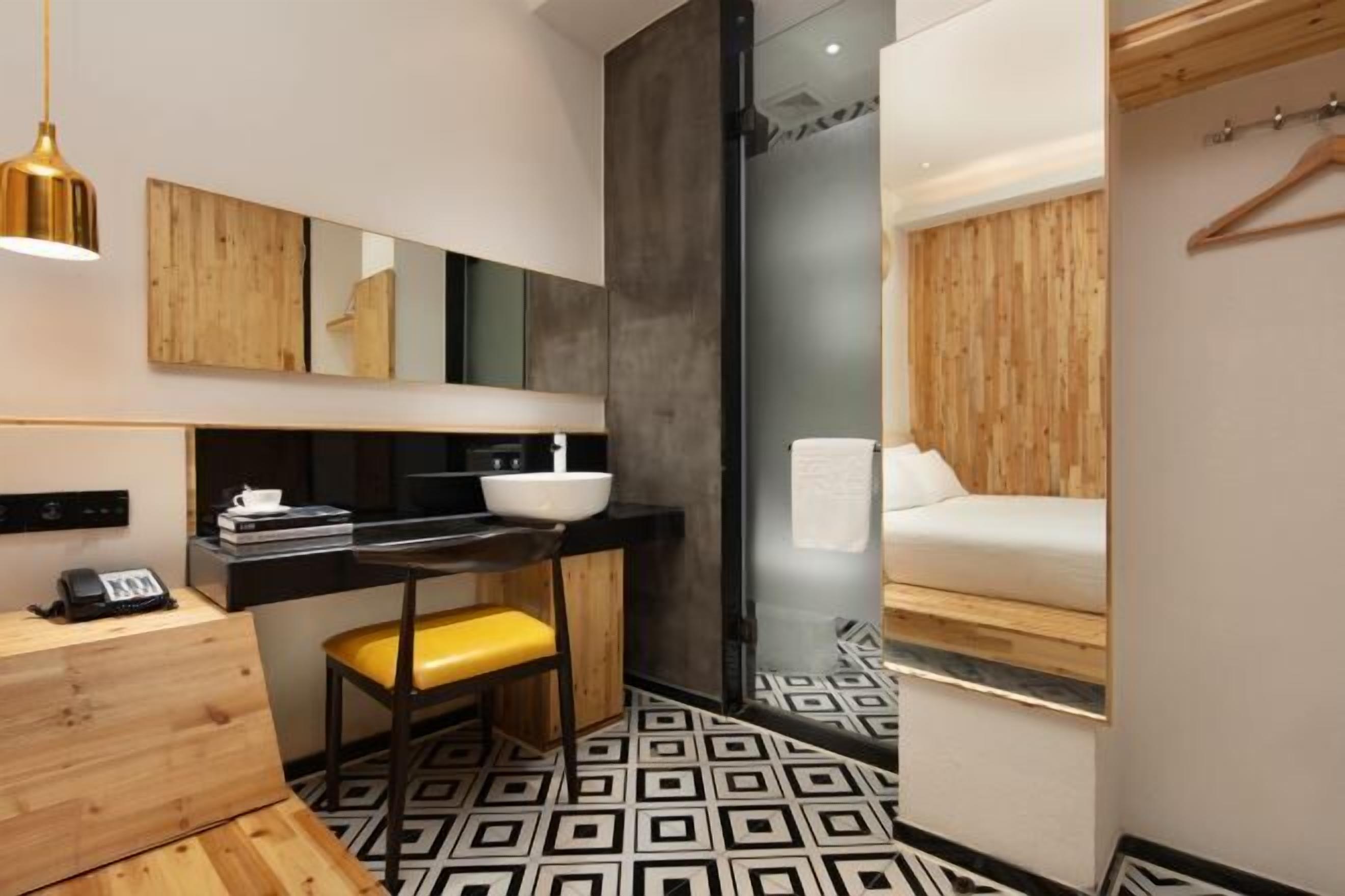 A modern bathroom with a wooden vanity, a sink, and a mirror.