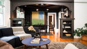 A modern living room with a dark-colored sofa, a round coffee table, and a bookshelf.