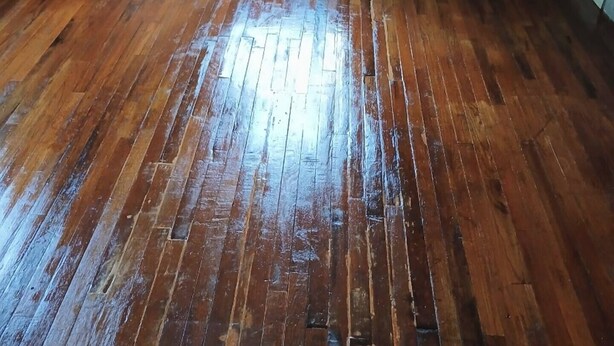 A room with a wooden floor, a window, and a white baseboard. - Big House on Broadway (Jacksonville)