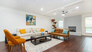 A spacious living room with a white sofa, a brown sofa, and a coffee table. - Pool | BBQ | Game Room | Gym | Patio | Workspace (Houston)
