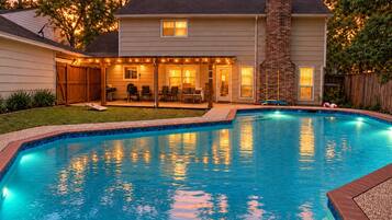 A swimming pool with a house in the background.