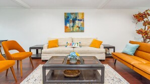 A living room with a sofa, two armchairs, a coffee table, and a painting on the wall. - Pool | BBQ | Game Room | Gym | Patio | Workspace (Houston)