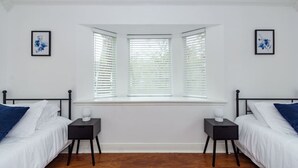 A bedroom with two beds, a window with blinds, and two bedside tables. - Pool | BBQ | Game Room | Gym | Patio | Workspace (Houston)