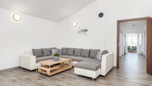 A modern living room with a sectional sofa, a wooden coffee table, and a small plant.