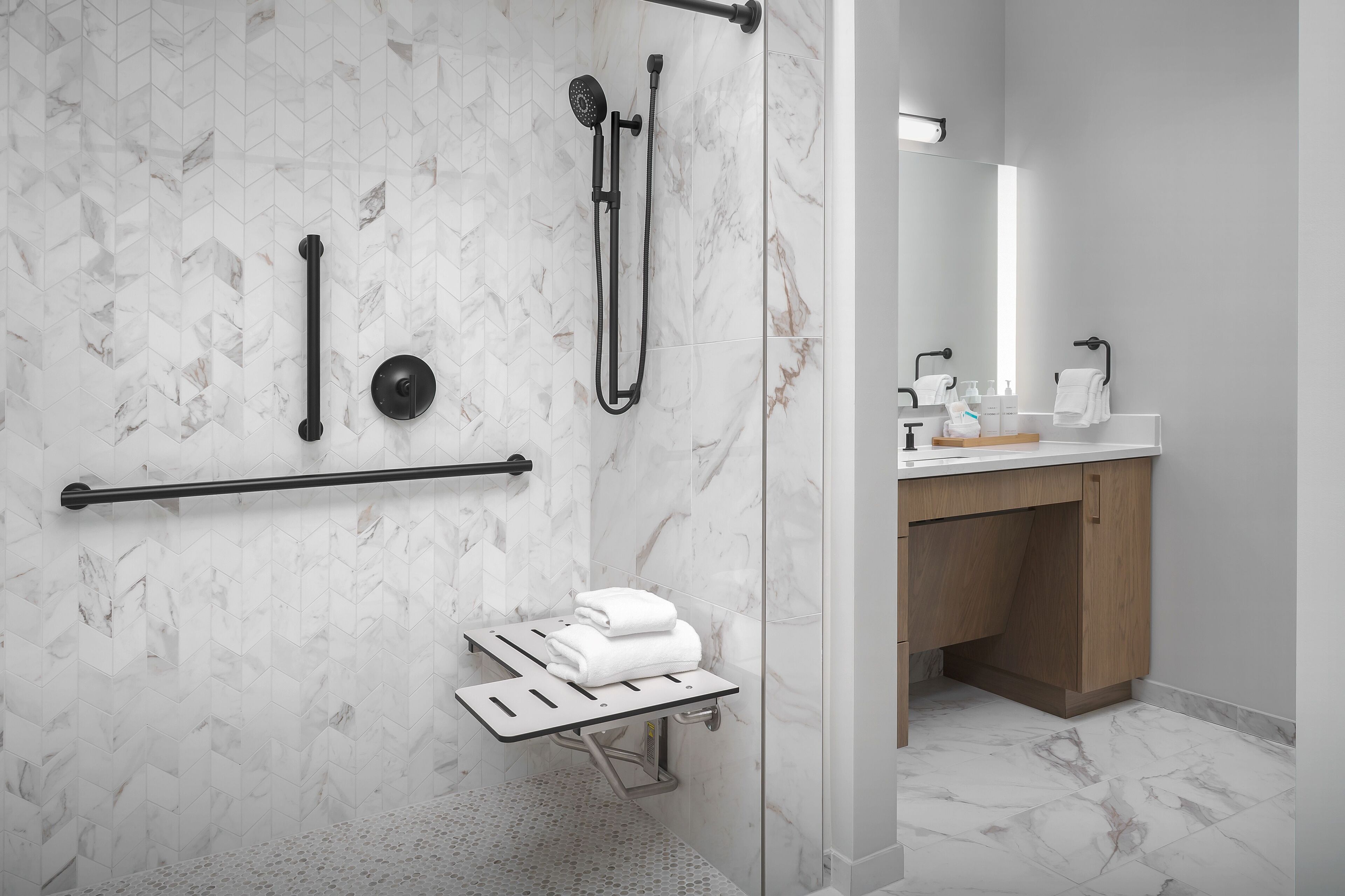A modern bathroom with a shower, a toilet, and a sink.