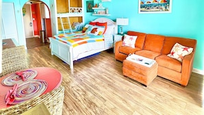 A bright room with a bed, a sofa, and a dining table. - NEW! 2nd Floor Studio w/Kitchen (Myrtle Beach)