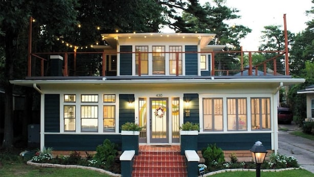 A two-story house with a front porch, a number '430' above the door, and a small garden with a bench.