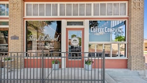 El Hotel Histórico Eastland, con fachada de ladrillo, ventanas amplias y el letrero de una compañía de café.