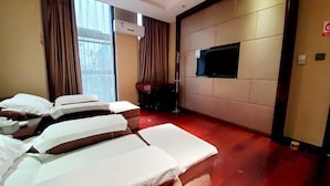 A hotel room with three beds, a flat-screen TV mounted on the wall, and a large window with curtains. - Yangzhou Convention Center(Mingyue Lake Store) (Yangzhou)