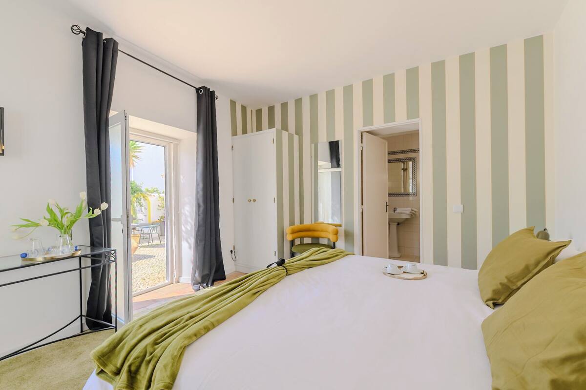 Une chambre d’hôtel équipée d’un lit, d’un bureau, d’une chaise, d’une salle de bain et offrant une vue sur l’extérieur.