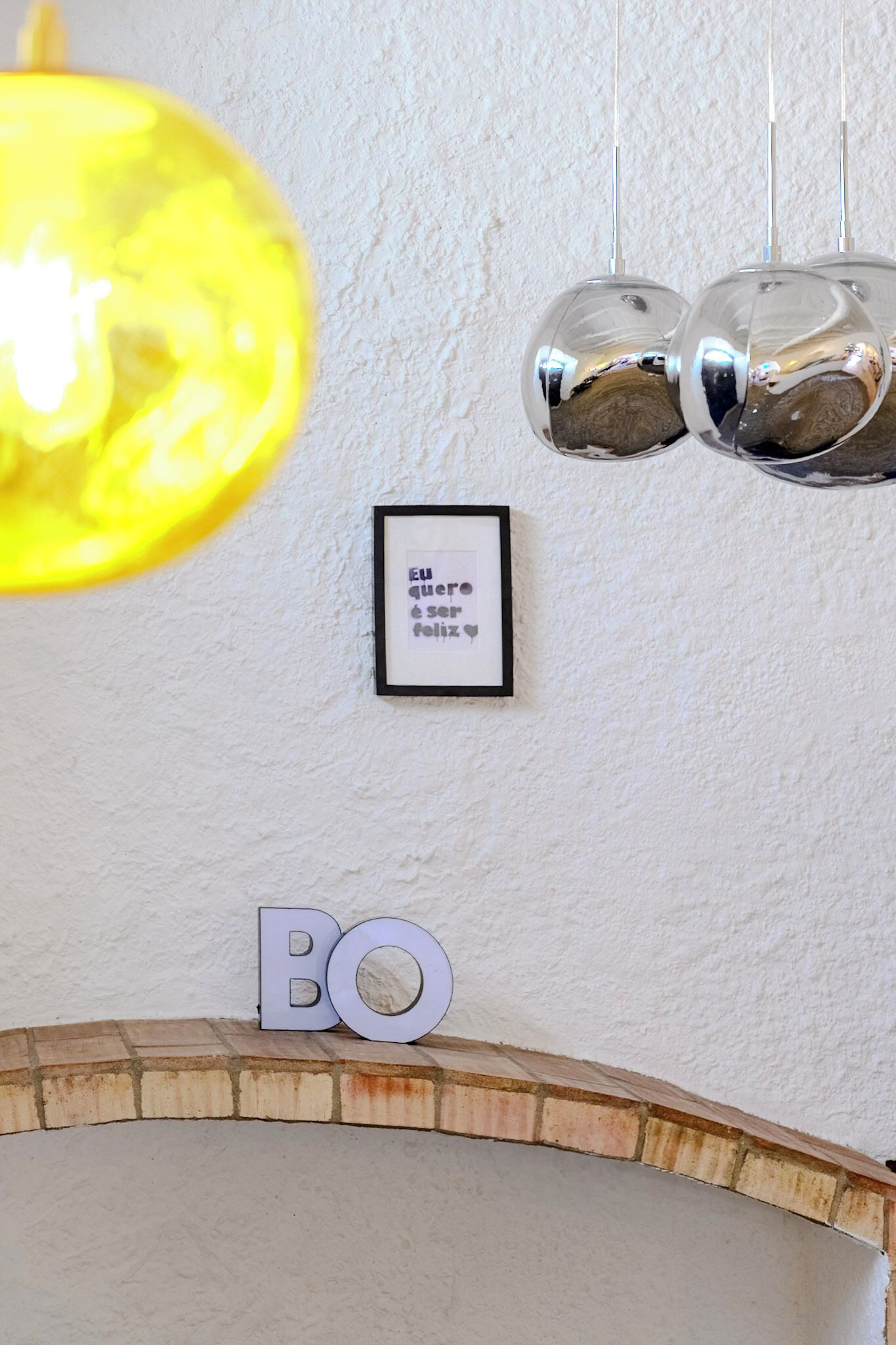 A framed quote on a wall, a 'BO' sign, and a brick fireplace.