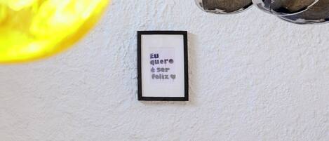 A framed quote on a wall, a 'BO' sign, and a brick fireplace.