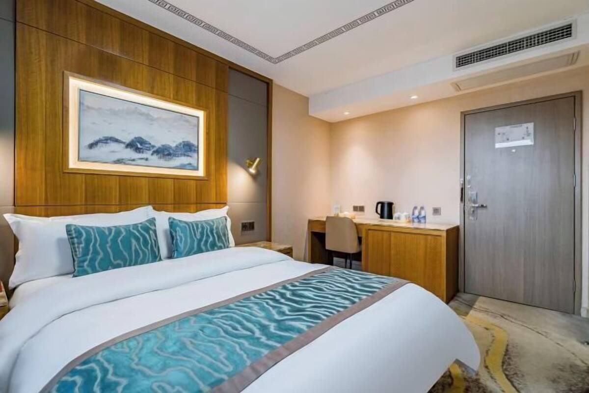 Een hotelkamer met een bed, een bureau en een deur.