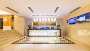 A hotel lobby with a reception desk, a staircase, and a tiled floor. - Beijing Fuyou Street Hotel (Xidan Branch) (Beijing)