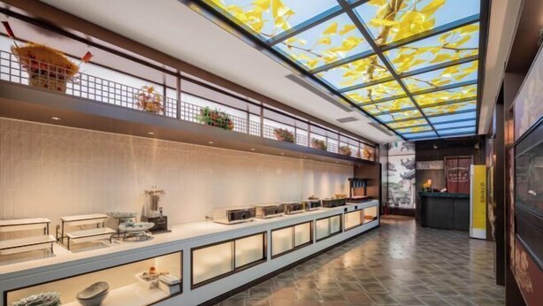 A spacious corridor with a high ceiling and skylight, leading to a reception area with a counter and seating. - Beijing Fuyou Street Hotel (Xidan Branch) (Beijing)