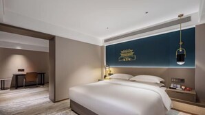 A hotel room with a large bed, a desk, and a chair. - Beijing Fuyou Street Hotel (Xidan Branch) (Beijing)