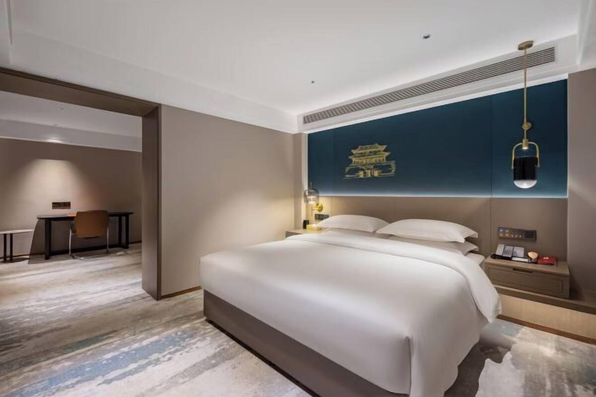 Een hotelkamer met een groot bed, een bureau en een stoel.