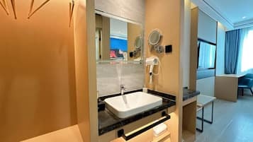 A modern bathroom with a white sink, mirrors, and a hairdryer.