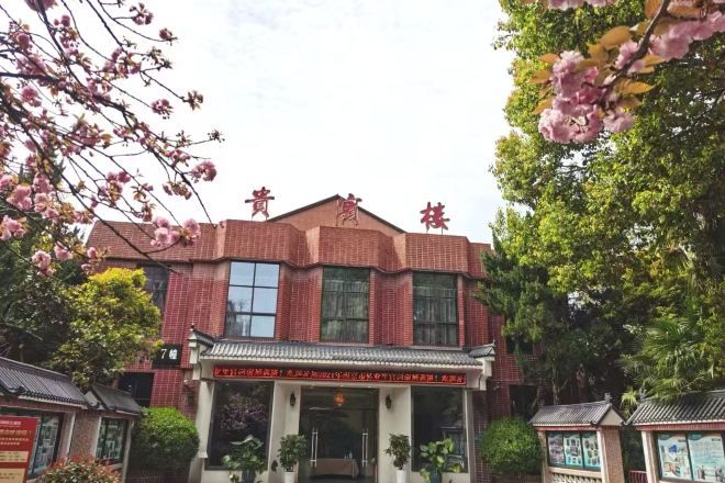 A red brick building with a traditional Chinese architectural style, featuring a tiled roof and a central entrance with a decorative archway.