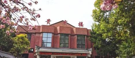 A red brick building with a traditional Chinese architectural style, featuring a tiled roof and a central entrance with a decorative archway.