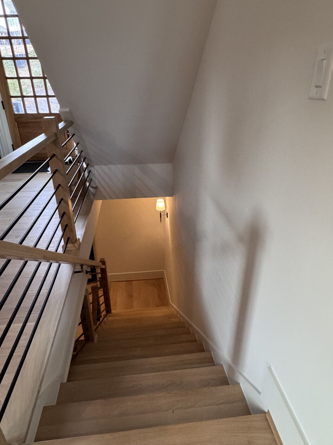 A wooden staircase with a handrail leading to a landing.