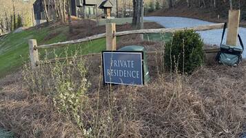 A sign indicating a private residence with a gravel path and a wooden fence.