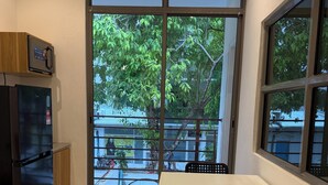 Una cocina pequeña con refrigerador, microondas y una mesa con dos sillas.