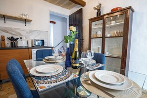 A dining table set with plates, a bottle of champagne, and glasses.