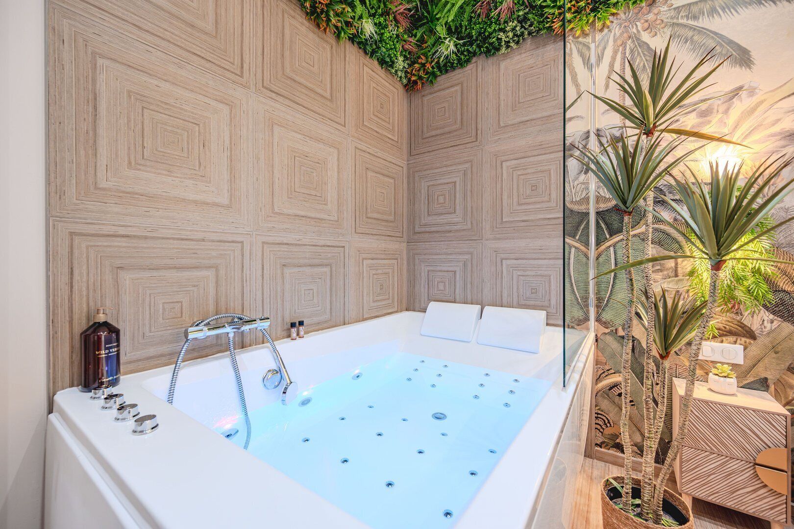 A spa room with a large bathtub, wooden panel walls, and a small plant area.